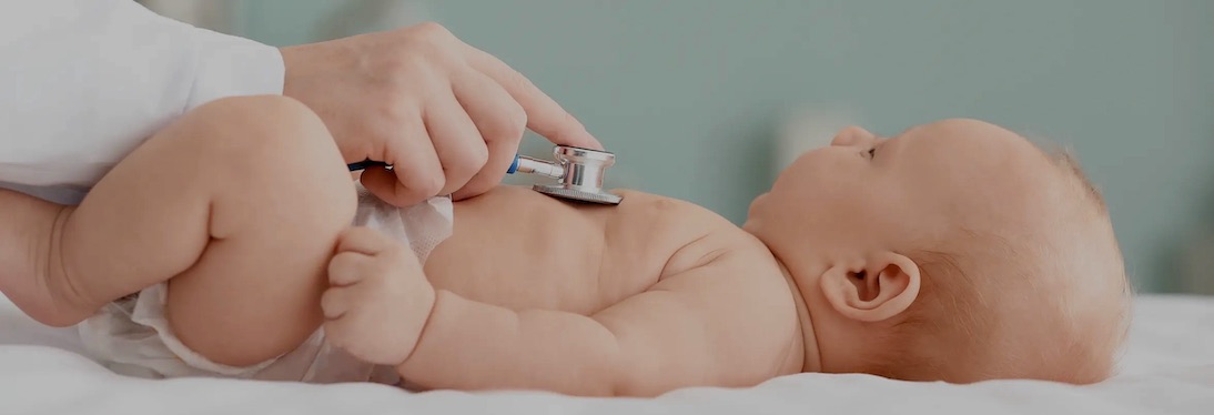 baby laying getting examined by a doctor with a stethoscope